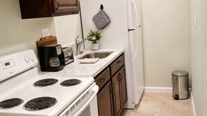 Una cocina con estufa, pileta y refrigerador.