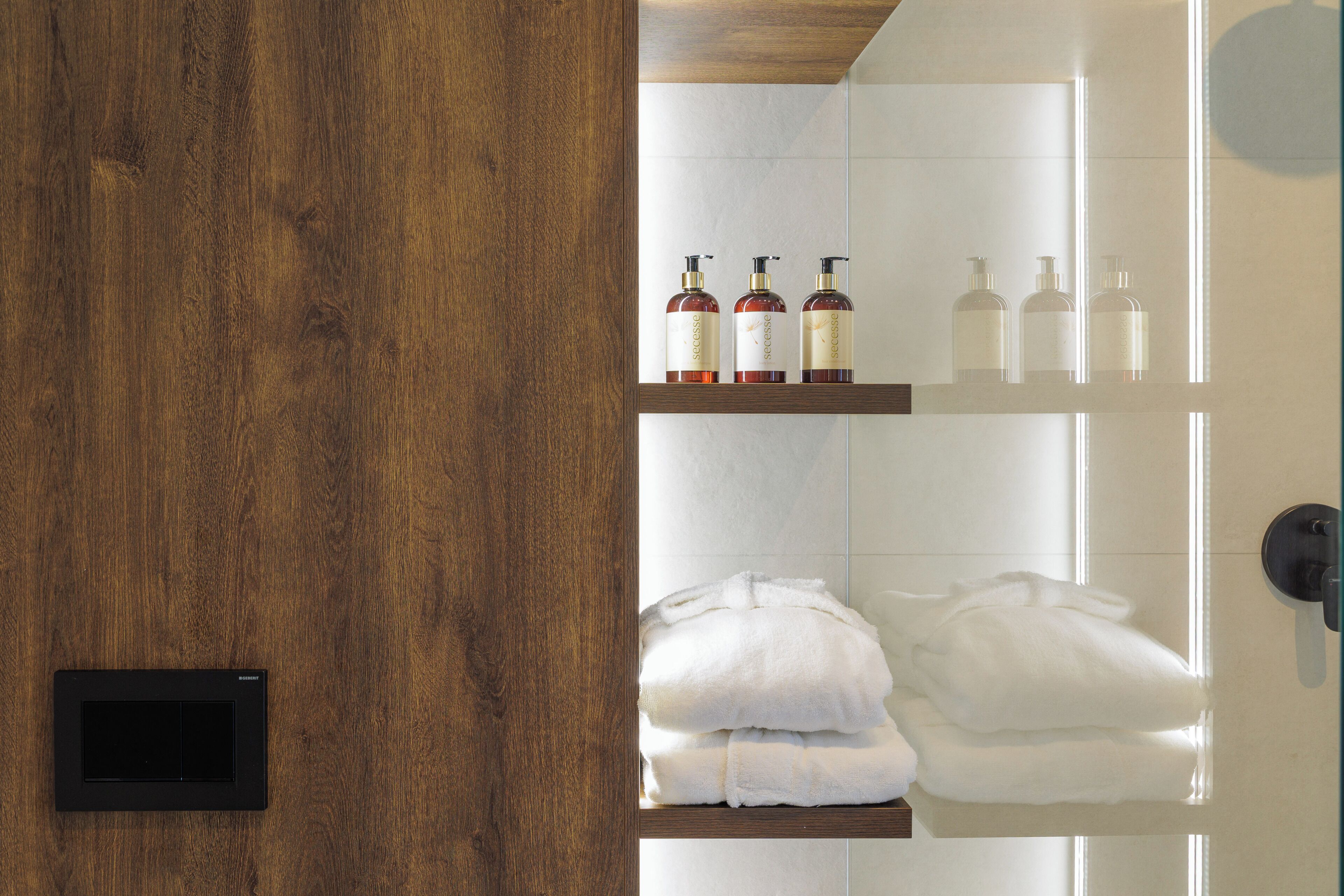 A bathroom with wooden shelves holding toiletries and towels.