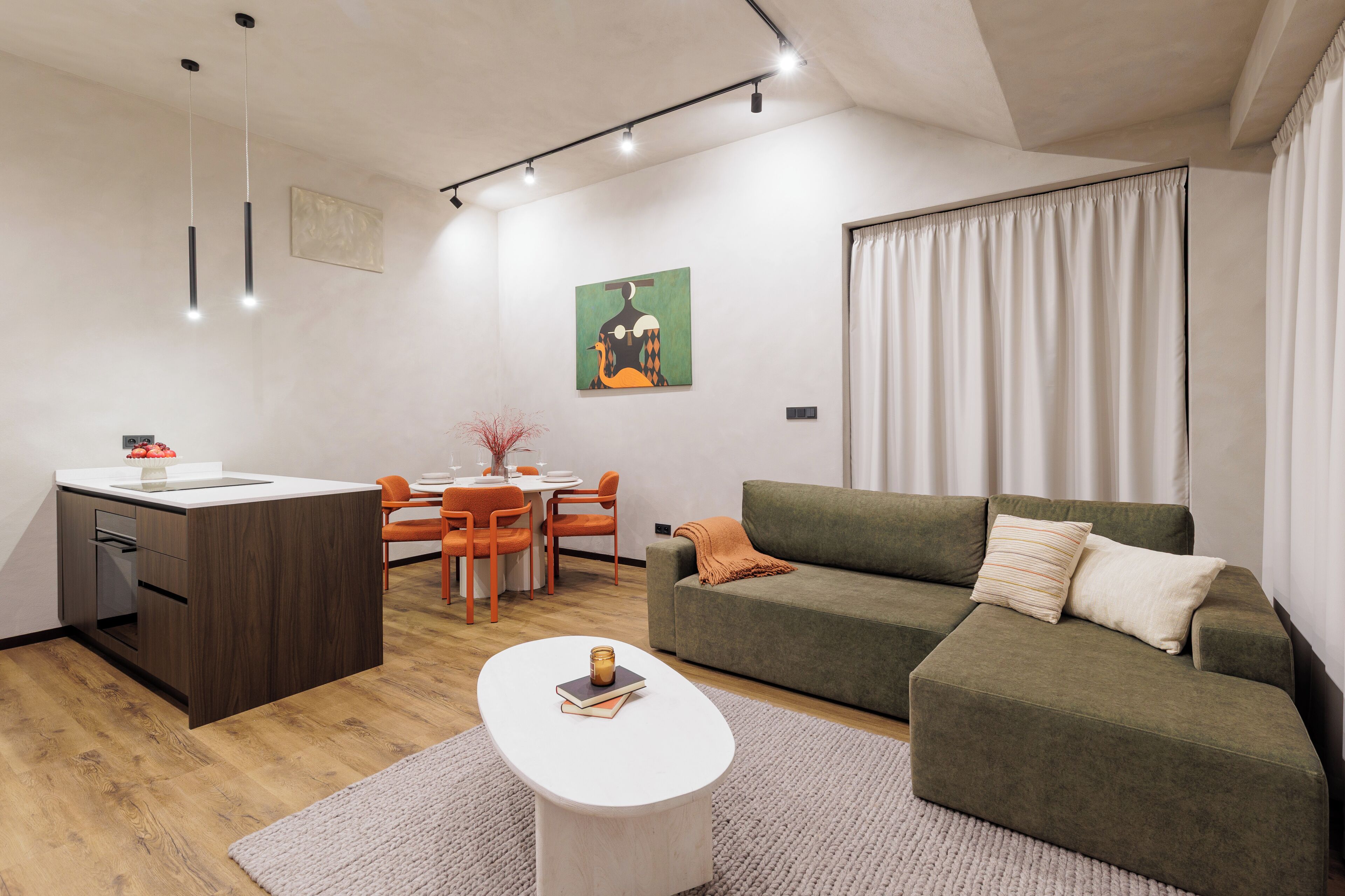 A modern living room with a sofa, a dining table, and chairs.
