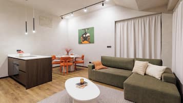 A modern living room with a sofa, a dining table, and chairs.