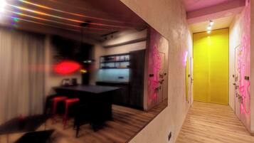 A modern interior with a bar area, wooden flooring, and a yellow door.