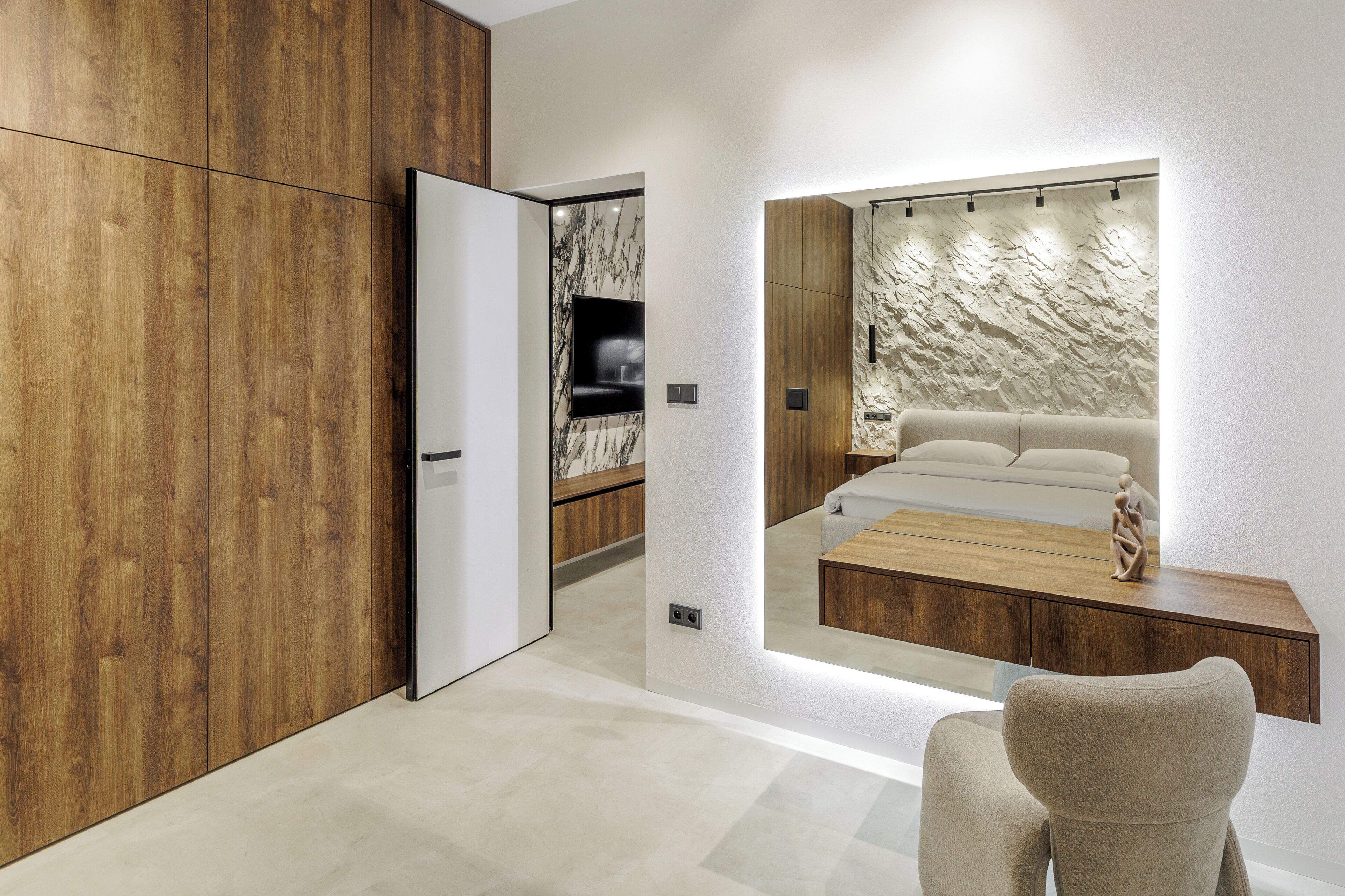 A modern room with a wooden wardrobe, a marble wall, a sofa, and a coffee table.