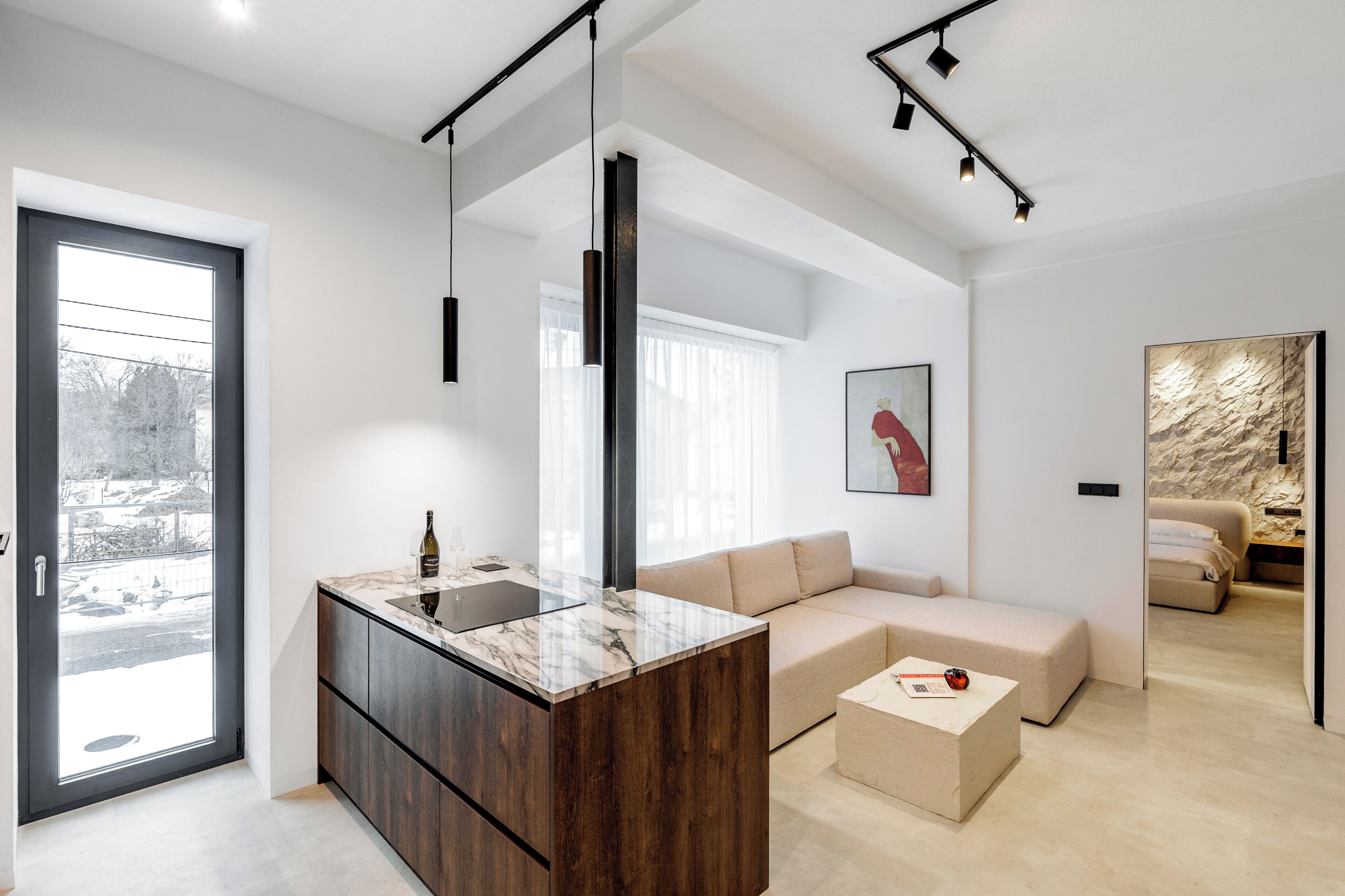 Una sala de estar moderna con una isla de mármol, un sofá y una mesa de centro.