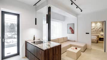 Una sala de estar moderna con una isla de mármol, un sofá y una mesa de centro.