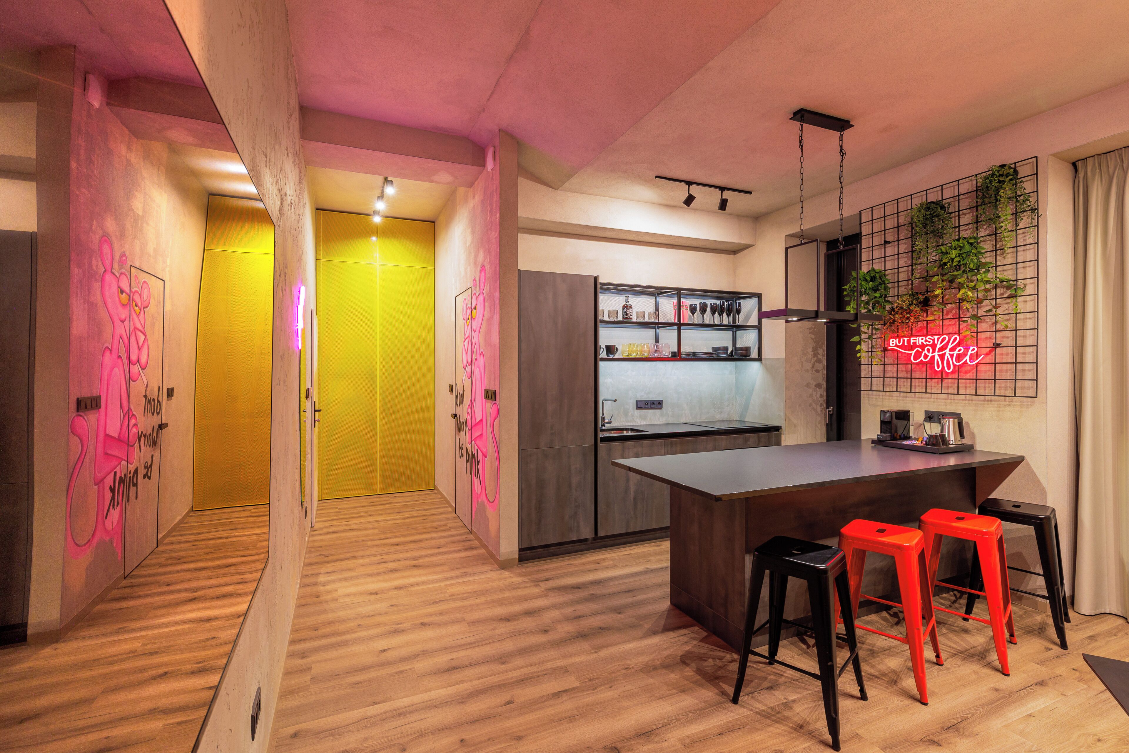 Cozinha moderna com ilha central, banquetas e um letreiro de neon.