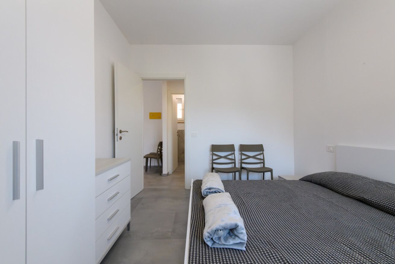 A bedroom with a bed, a wardrobe, a desk, and two chairs. - A bright and practical 60 square meters apartment, perfect for two people, located on the second floor of a building with an elevator (NOT accessible to people with disabilities).The property is situated in a quiet area and is ideally located for those w (Marotta)
