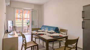 A dining area with a table set for four, a blue sofa, and a kitchen area with a refrigerator. - A bright and practical 60 square meters apartment, perfect for two people, located on the second floor of a building with an elevator (NOT accessible to people with disabilities).The property is situated in a quiet area and is ideally located for those w (Marotta)