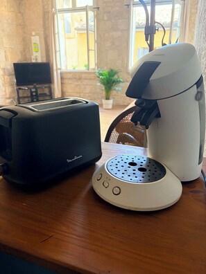Eine Küche mit Toaster, Kaffeemaschine und einer Topfpflanze.