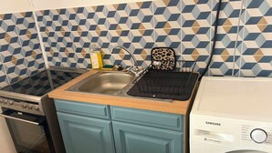 A compact kitchen with a stove, sink, and washing machine. - Downtown (Montpellier)