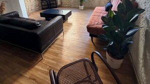 A living room with a sofa, a chair, a TV, and a potted plant. - Downtown (Montpellier)