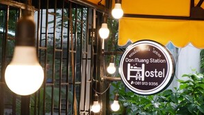 A hostel sign with a contact number. - Donmueang Station Hotel (Bangkok)