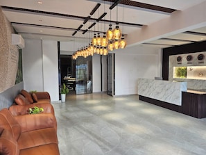 A modern hotel lobby with a reception desk, seating area, and a large chandelier. - Hotel Tulip Hyderabad Airport Zone (Hyderabad)