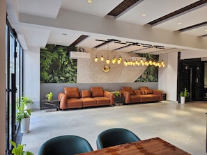 A modern lobby with a sofa set, a wooden table, and a large wall mural. - Hotel Tulip Hyderabad Airport Zone (Hyderabad)