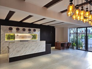 A hotel reception desk with a marble top, multiple clocks, and a digital display. - Hotel Tulip Hyderabad Airport Zone (Hyderabad)