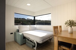 Una habitación compacta con cama, una mesa de comedor y ventana con vistas al paisaje.