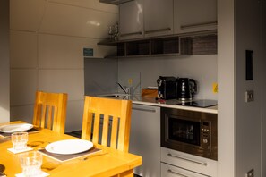 A compact kitchen with a microwave, coffee maker, and a small refrigerator. - Waterfront Wave Cabin at Lost Shore Surf Resort (Newbridge)