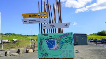 A directional sign with arrows pointing to Lost Shop, Waterfront Accommodation, and Hilltop Lodges.