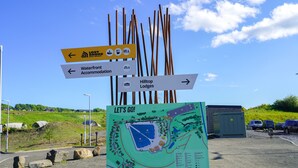 A directional sign with arrows pointing to Lost Shop, Waterfront Accommodation, and Hilltop Lodges.