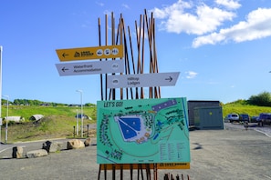 A directional sign with arrows pointing to Lost Shop, Waterfront Accommodation, and Hilltop Lodges.