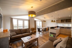 Un salon moderne avec un canapé, une table basse et un coin repas.