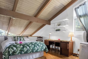 Ein Schlafzimmer mit Bett, Schreibtisch, Stuhl, Lampe und einem Fenster mit Vorhängen.