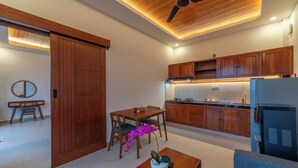 Una cucina moderna con mobili in legno, un'area pranzo con tavolo e sedie, e una ventola a soffitto.