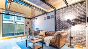 Ein gemütliches Wohnzimmer mit einem Ledersofa, einem Couchtisch und einer Lampe.