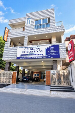 Un hotel con un cartel que anuncia habitaciones de lujo, datos de contacto y un logotipo.