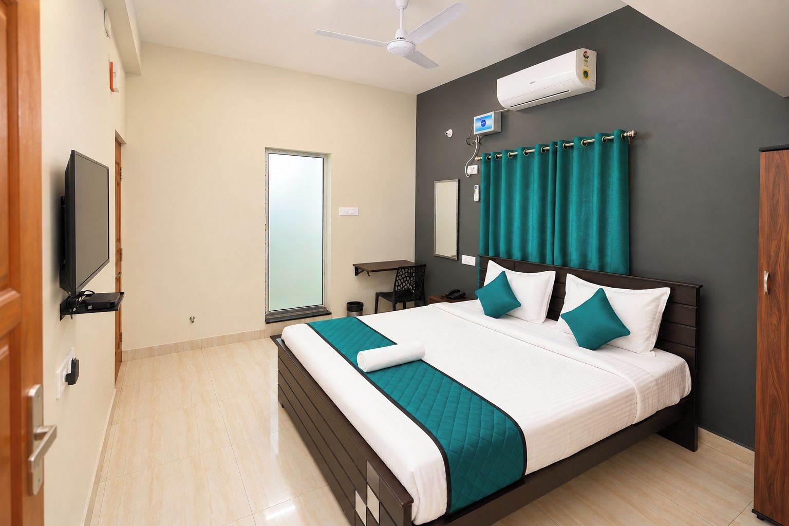 A hotel room with a bed, a television, an air conditioning unit, a window with curtains, and a ceiling fan.
