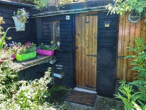 Une structure en bois dotée d’une porte, d’une petite fenêtre et d’une pancarte indiquant « Eau potable ».