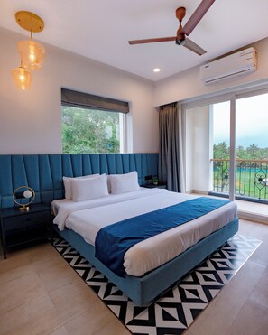Un dormitorio moderno con una cama grande, un ventilador de techo y vistas al exterior.