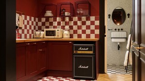 A kitchen with checkered tiles, a microwave, a coffee maker, and a Marshall amplifier. - Guestready - Camden Studios (London)