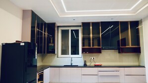 Una cocina moderna con horno empotrado, ventana y lavamanos.
