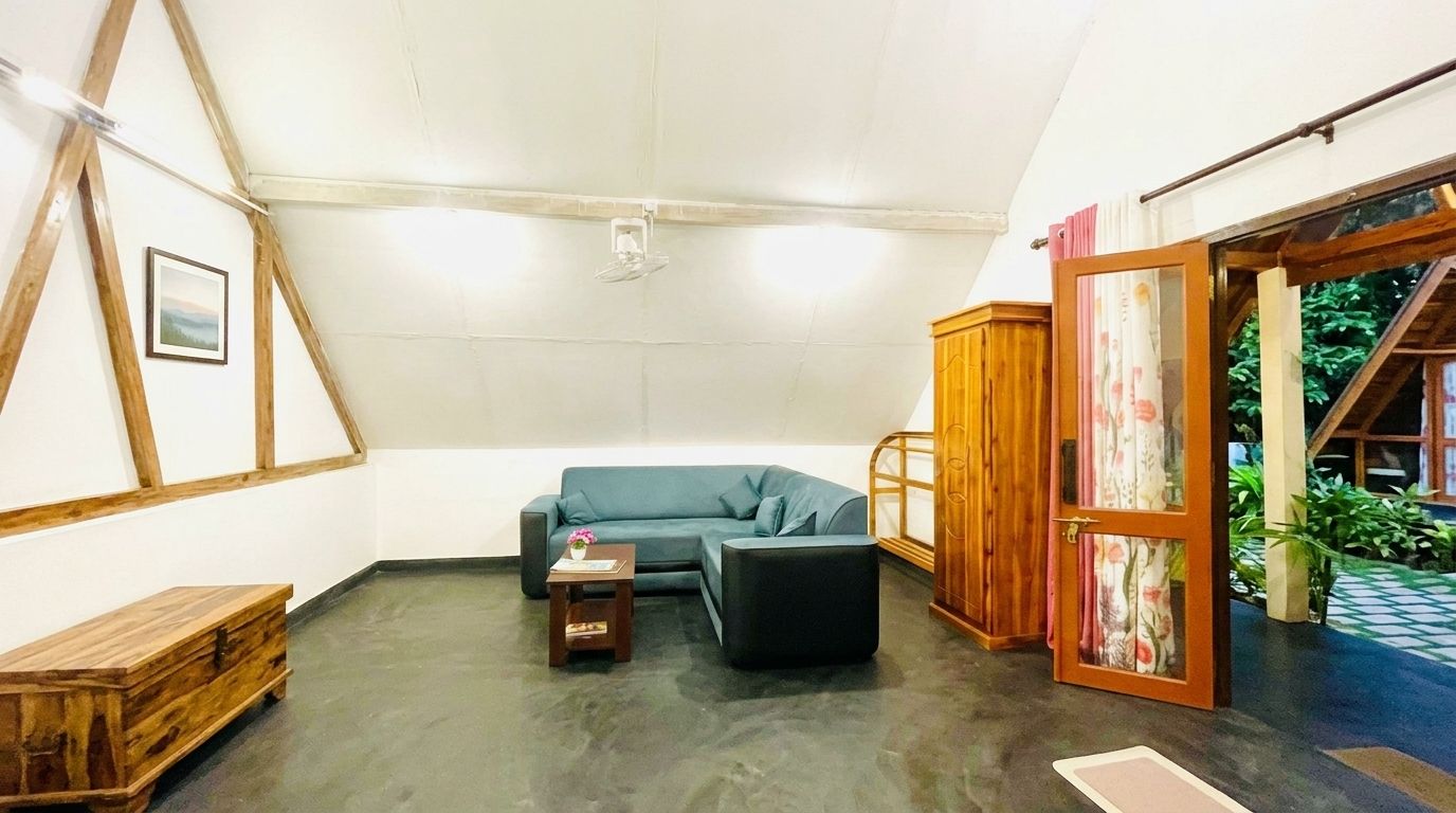 A room with a wooden ceiling, a blue sofa, a small table, and a cabinet.
