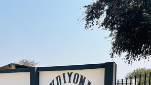A sign for 'INDYONA MALROSE GUEST HOUSE' with contact numbers.