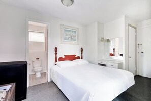 A bedroom with a bed, a bedside table, a mirror, a toilet, and a door. - Everything You Need for a Great Stay! Outdoor Pool, Pets Are Welcome Here! (Honolulu)
