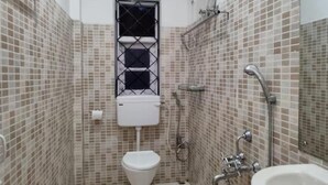 Een kleine badkamer met toilet, douche en wastafel.