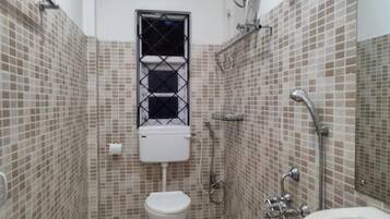 A small bathroom with a toilet, a shower, and a sink.