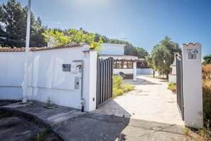 A gated entrance to a property with a clear pathway leading to a covered area. - GuestHost - I Mandorli: A Villa Between the Sea and Downtown (Quartu Sant'Elena)