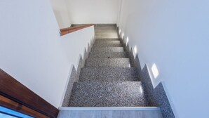 Eine Treppe mit einem hölzernen Geländer und einer weißen Wand.