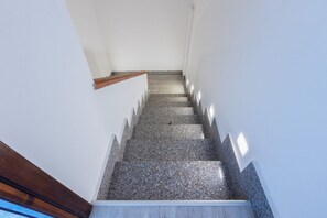 A staircase with a wooden handrail and a white wall. - GuestHost - I Mandorli: A Villa Between the Sea and Downtown (Quartu Sant'Elena)