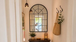 A hallway with a wooden table, a hanging plant, a mirror, and a hanging basket. - Casa del Parque Tacoronte Centro (Tacoronte)