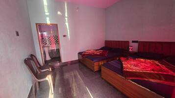 A room with two beds, a chair, and a small table.
