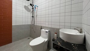 Un baño con inodoro, lavabo y ducha.