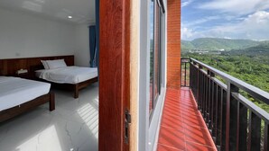 Un balcón con vistas a colinas verdes, una cama de madera y una ventana con una vista.