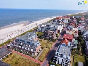 Une ville côtière dotée d’une plage, de bâtiments modernes et d’une route.