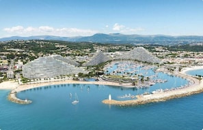 Hotel a la costa amb port esportiu, diverses piscines i platja.