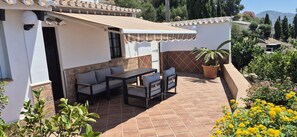 A patio with a table and chairs, a white awning, and potted plants. - Jo's 11 - peace and relaxation with a lot of sun and sea (Arenas)