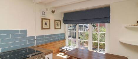 A kitchen with a stove, oven, and window with a view of the outside.
