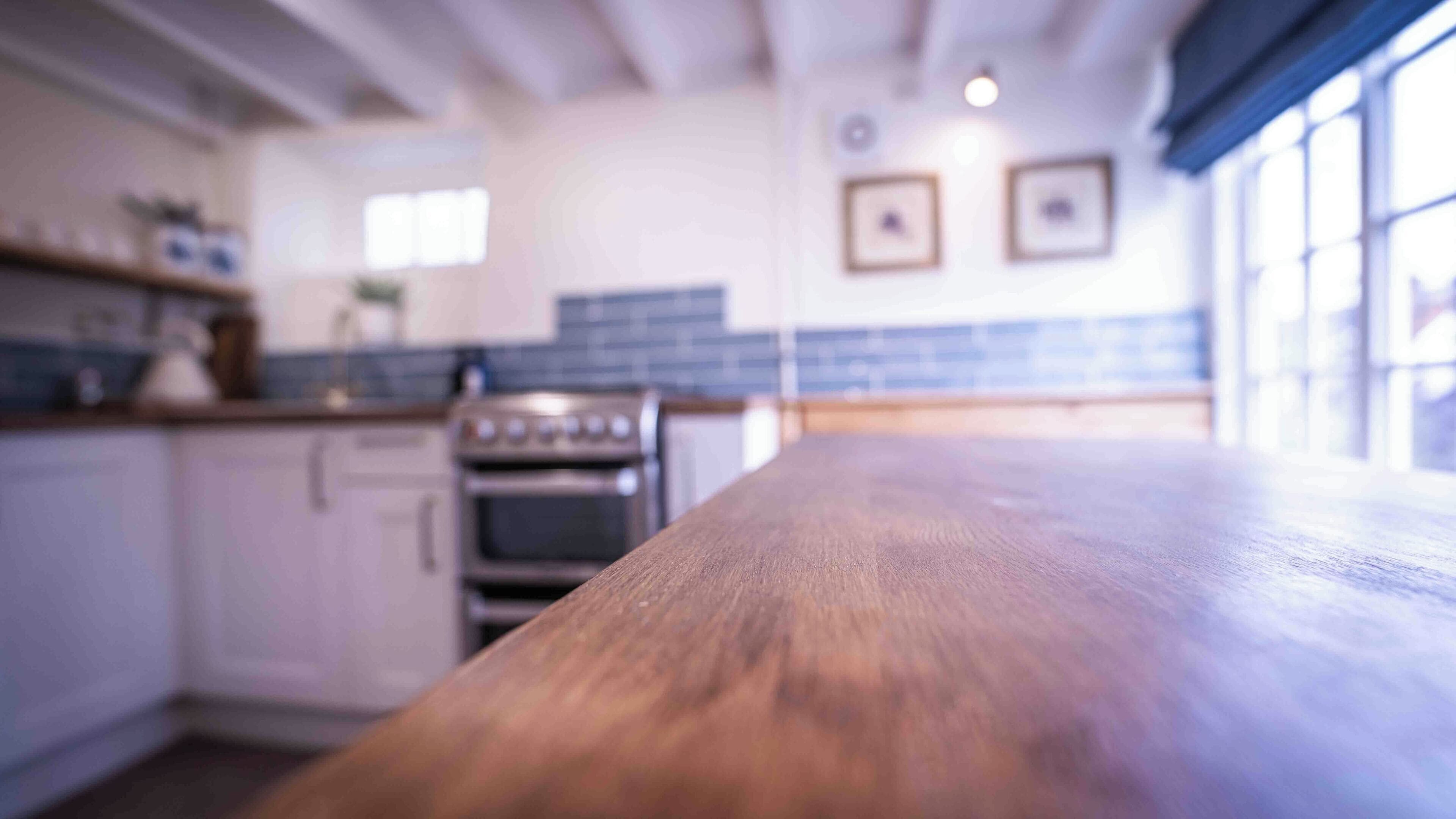 A kitchen with white cabinets, a wooden countertop, and a stove.